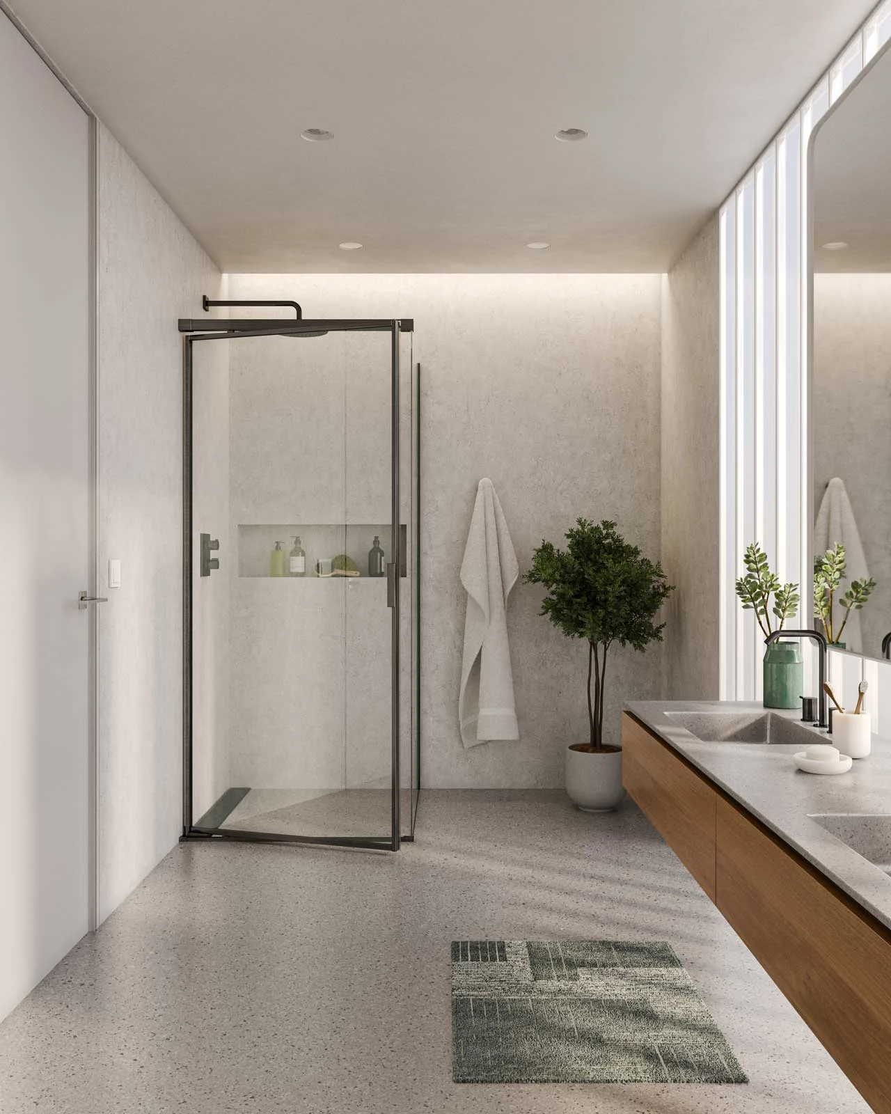 A pale bathroom with a black-framed shower, long timber vanity, green patterned mat and green accents beside the basin.