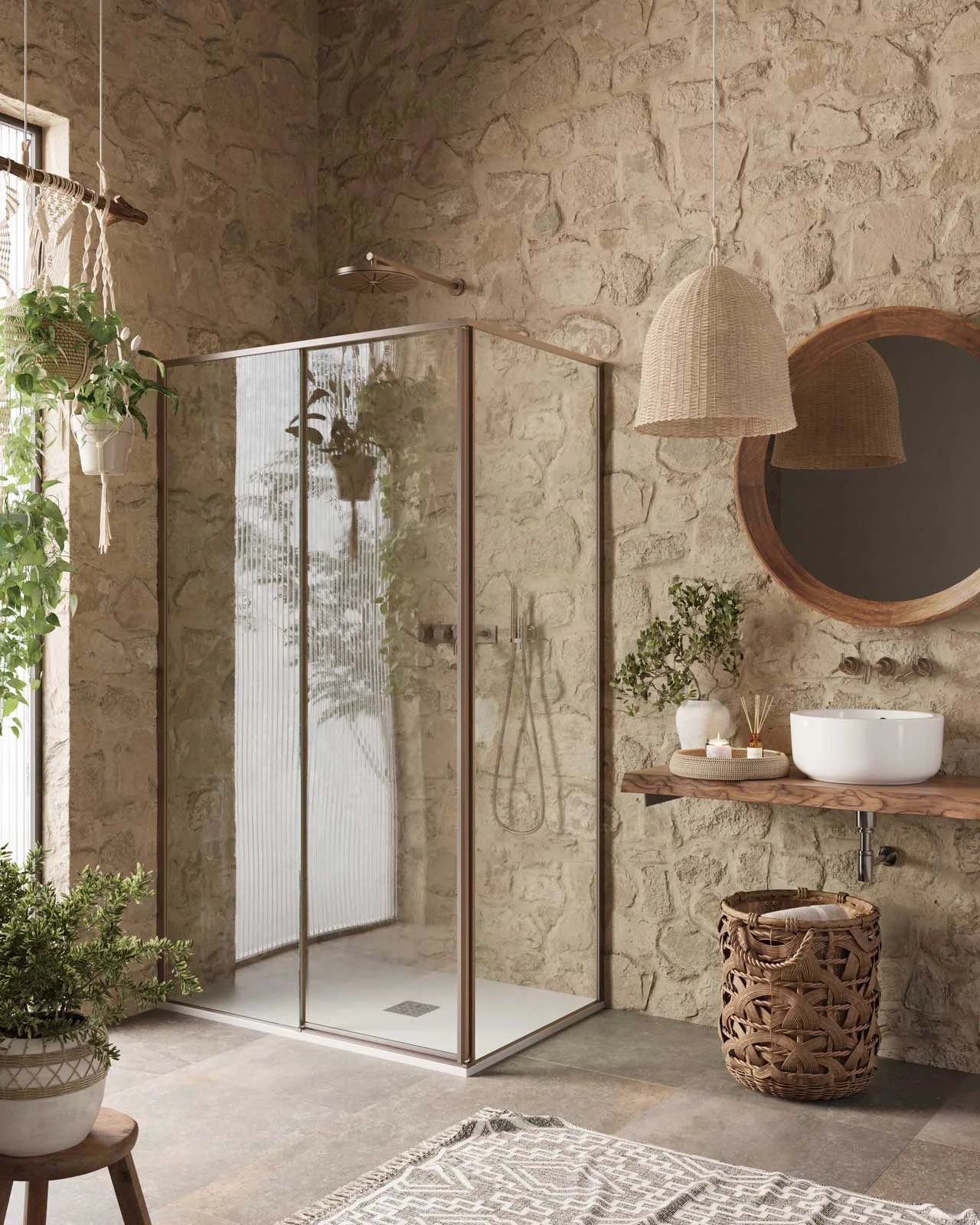 A glass shower and white basin against irregular stone walls, with a timber shelf, woven pendant and leafy plants.